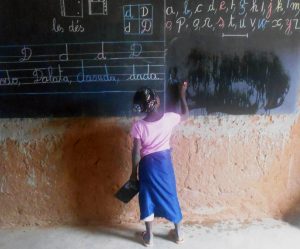 Fadderbarnet (flicka) i Mopti skriver på tavla i Barnfondens nyöppnade skola.